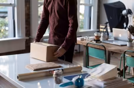 man tying box with string